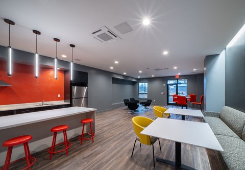 a lounge area with a table and chairs and a kitchen